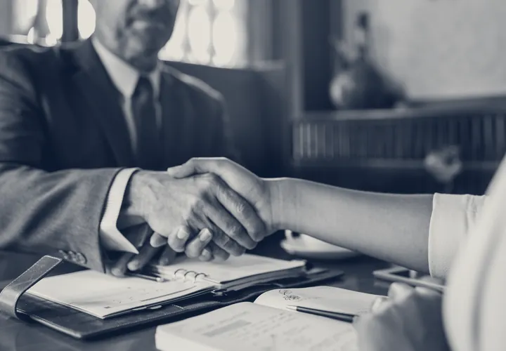 Attorneys shaking hands across a desk
